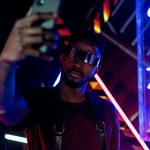 Cyberpunk-inspired selfie with neon lights and futuristic sunglasses.